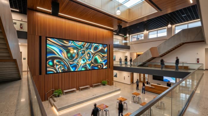 Wide LED display on a wood wall in a large lobby